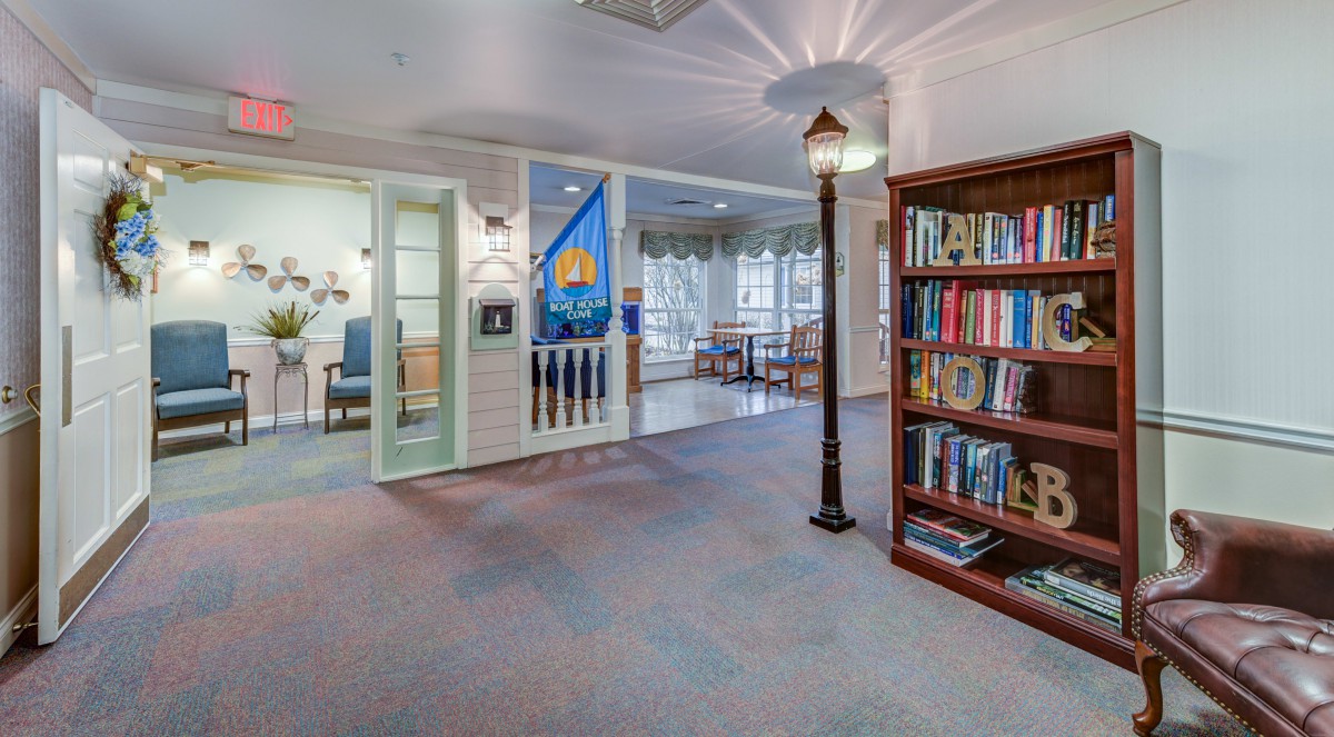 A cozy interior space featuring a bookshelf, decorative lamp post, and a comfortable reading area.