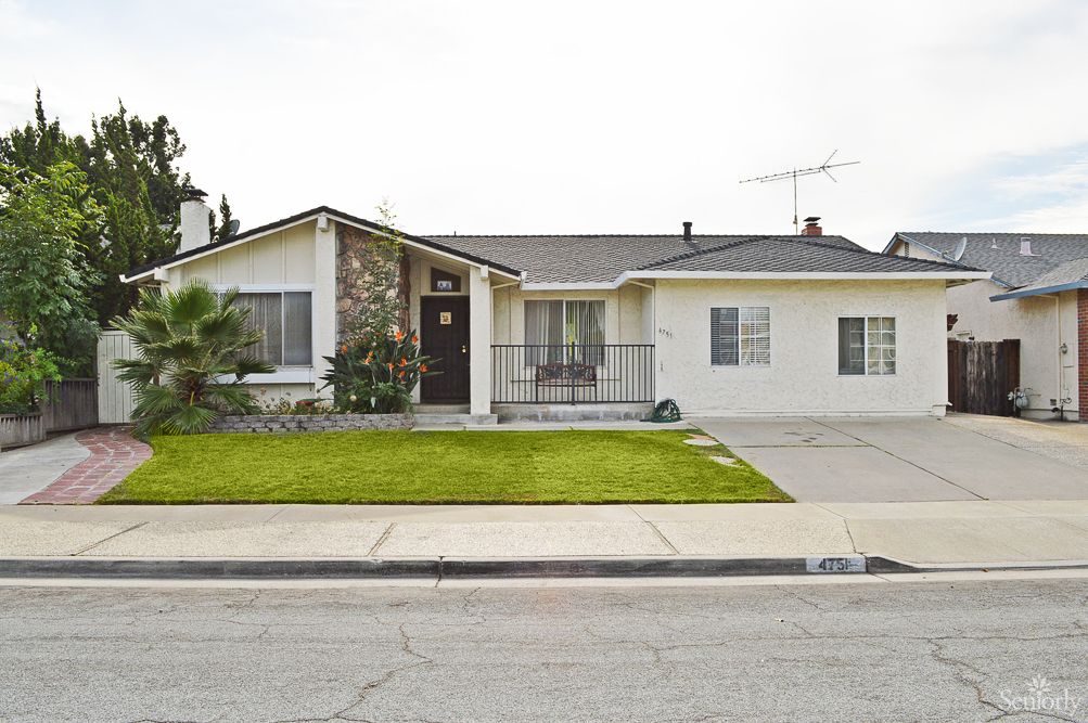 A single-story suburban house with a well-maintained lawn and driveway.