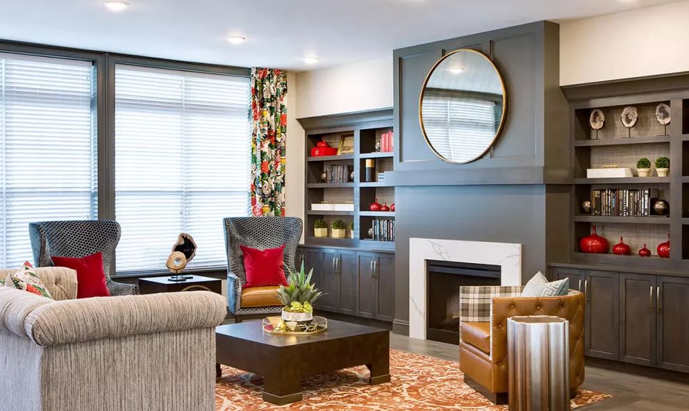 A modern living room featuring a cozy fireplace, stylish armchairs, and an elegant bookshelf.