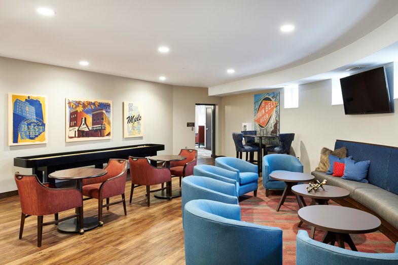 A modern lounge with comfortable seating and colorful artwork on the walls.