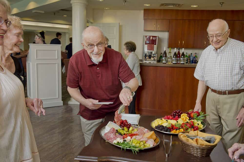 A man serving himself from a buffet table at a social gathering.