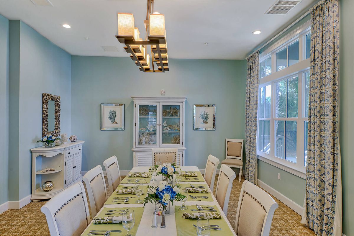 A beautifully arranged dining room with an elegant table setting and a modern chandelier.