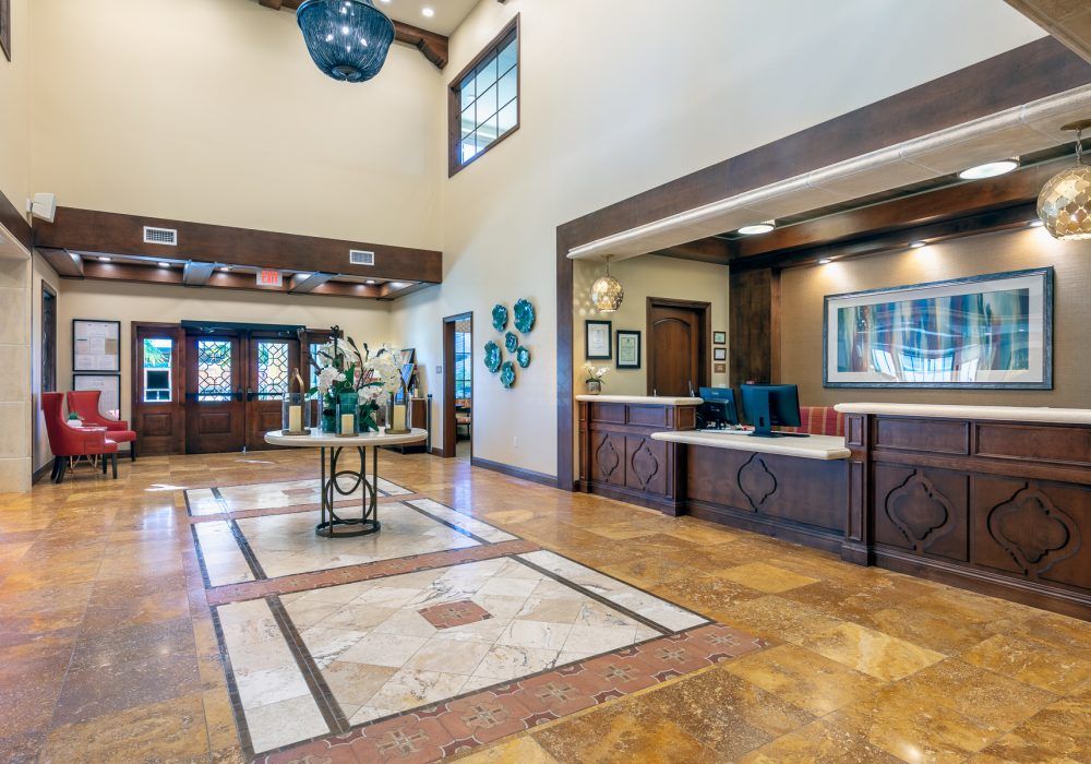 A spacious and elegantly designed hotel lobby with a reception desk and modern decor.