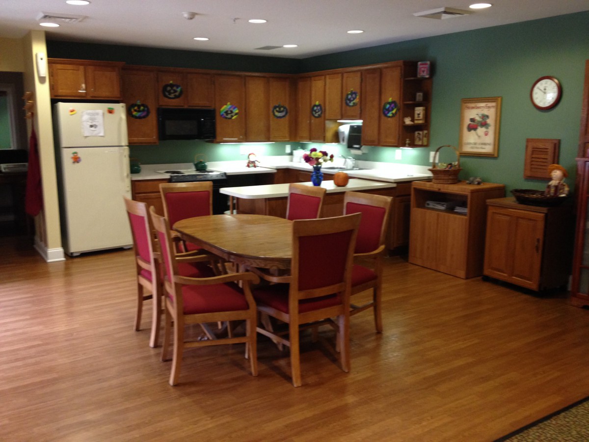 A cozy kitchen and dining area with wooden cabinets and a dining table surrounded by chairs.