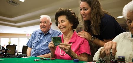 A group of elderly people enjoying a game of poker together, smiling and having fun.