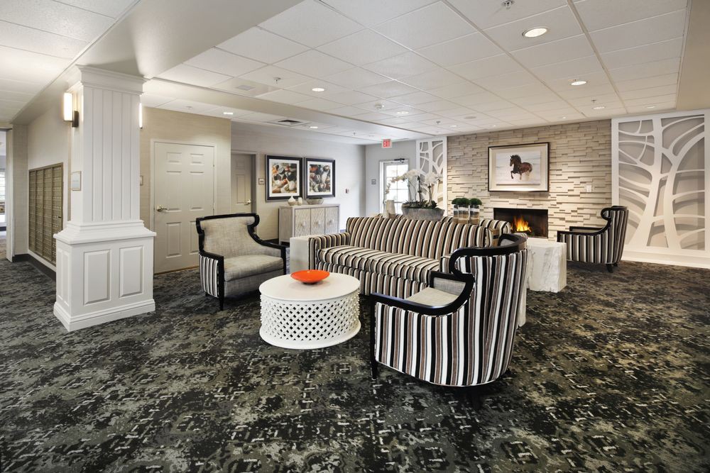 A modern lobby featuring a stylish seating area with striped furniture and a cozy fireplace.
