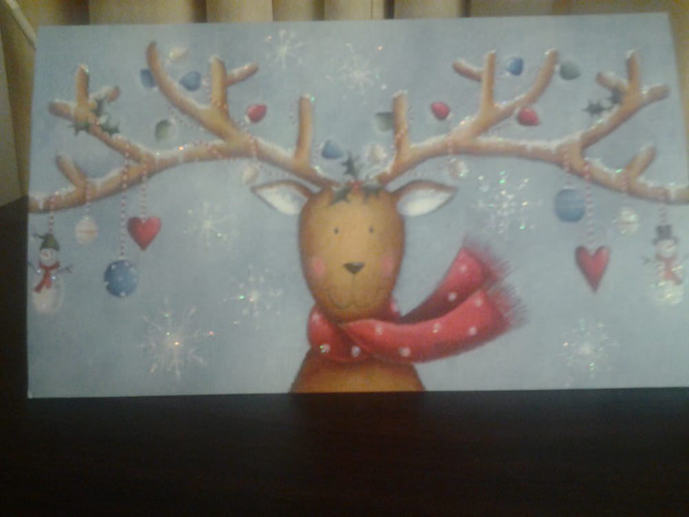 A cute illustration of a reindeer wearing a red scarf, surrounded by hearts.