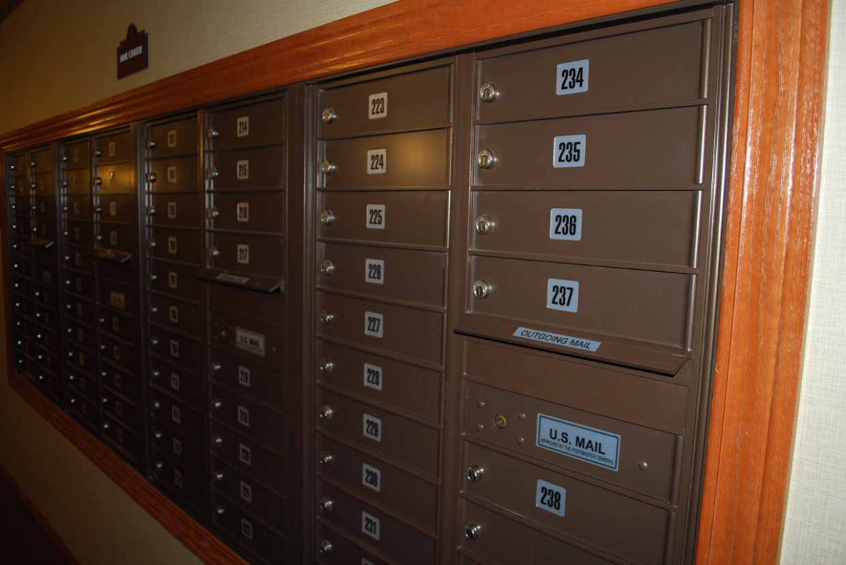 A row of indoor mailboxes with numbered slots and locks.
