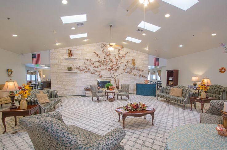 A welcoming lobby with plush seating and a decorative wall feature under skylights.