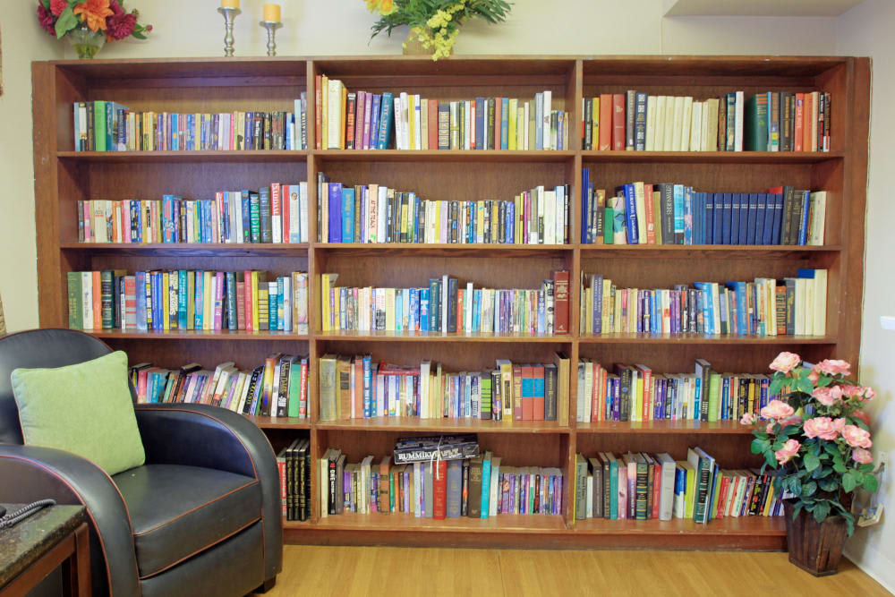 A cozy library corner with a large wooden bookshelf filled with books.