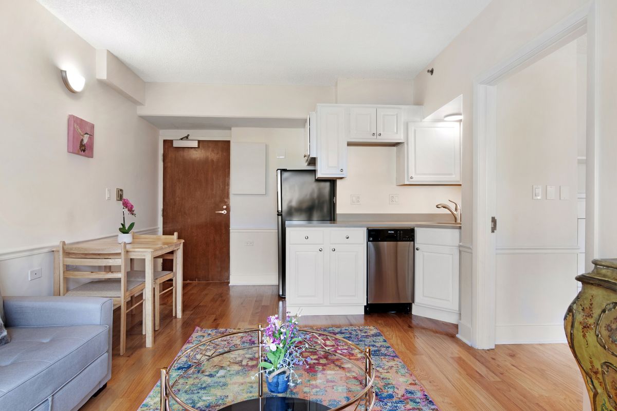 A modern small apartment with a minimalist kitchen and living area.