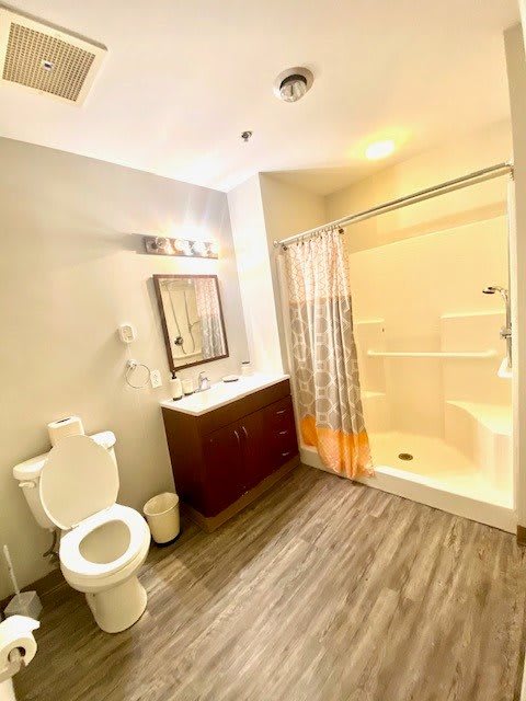 A bright and modern bathroom featuring a shower, sink, and toilet.