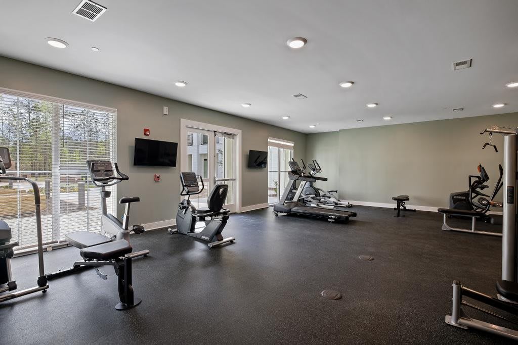 A modern gym equipped with treadmills and stationary bikes.