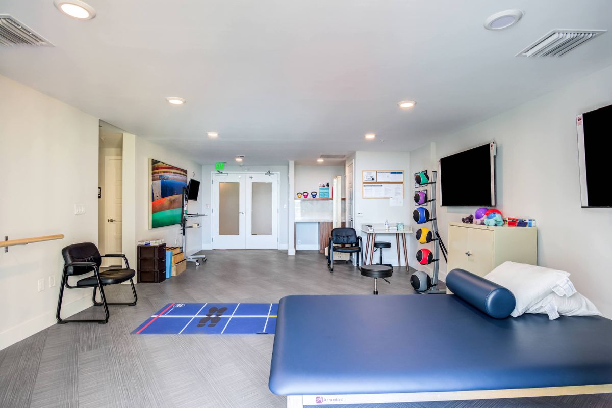 A spacious and modern physical therapy room equipped with exercise equipment and tools for rehabilitation.