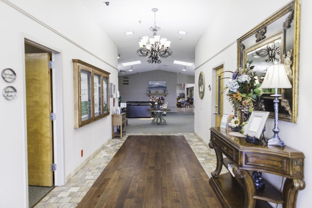 A well-decorated hallway with a chandelier, wooden floor, and elegant furnishings.