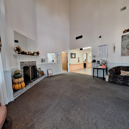 A spacious living room featuring a high ceiling, stylish decor, and a cozy fireplace.
