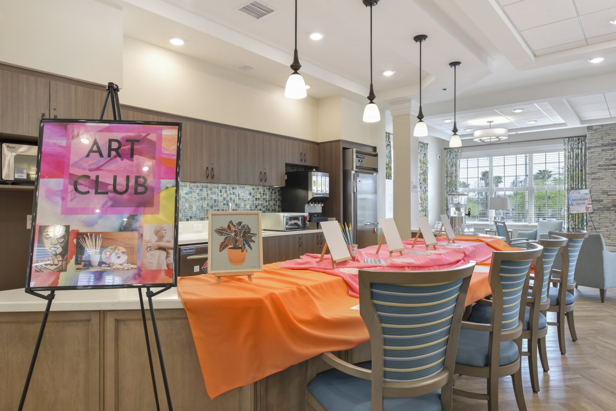 An inviting art club setup with vibrant tablecloths in a modern kitchen area.