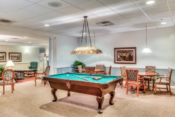 A cozy game room featuring a billiard table and comfortable seating.