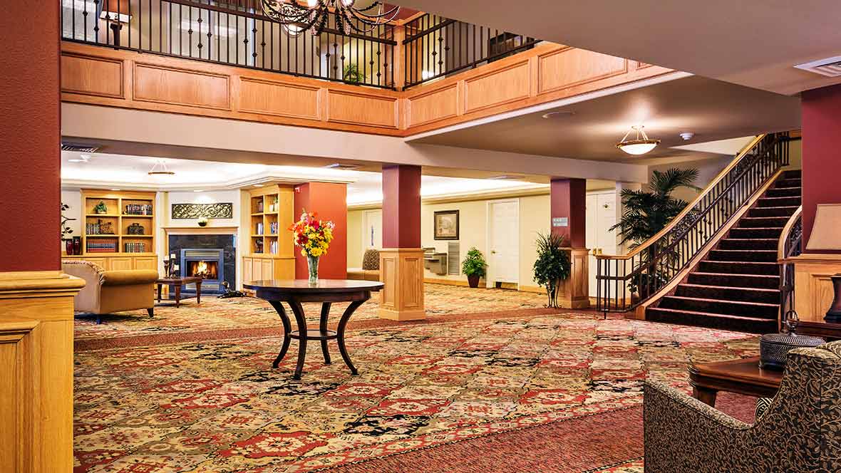 A luxurious hotel lobby with elegant furnishings and a richly patterned carpet.