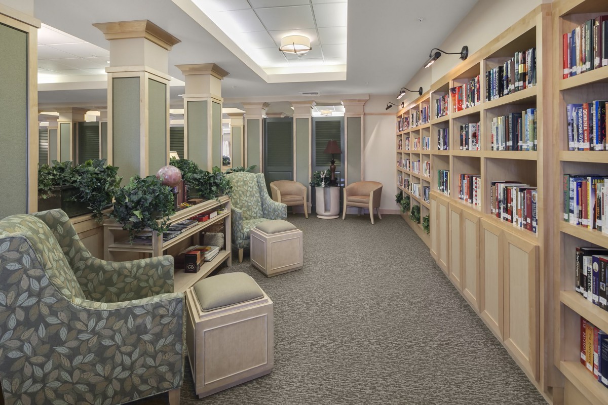 A cozy library reading room with bookshelves and comfortable seating.