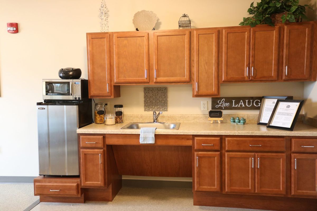A cozy kitchen interior featuring wooden cabinets and modern appliances.
