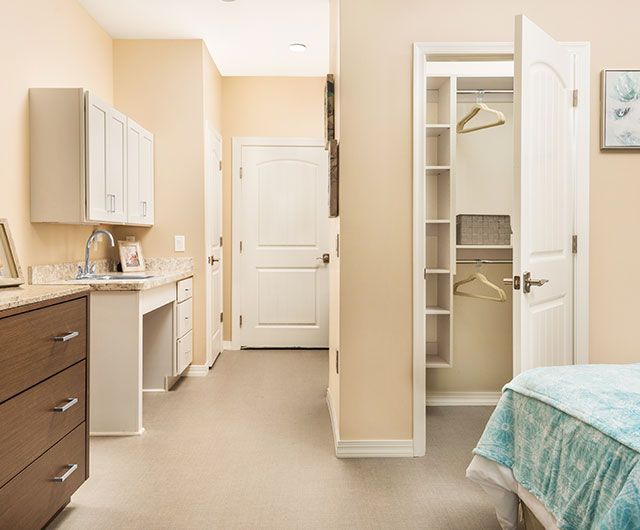 A modern bedroom interior with an open closet and light-colored decor.
