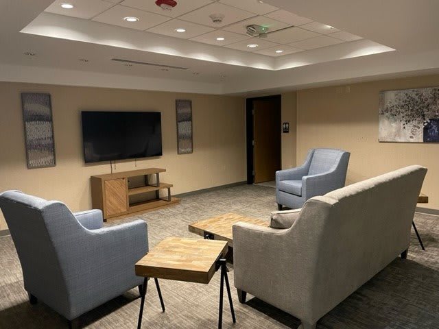 A modern and cozy living room with comfortable seating and a flat-screen TV.