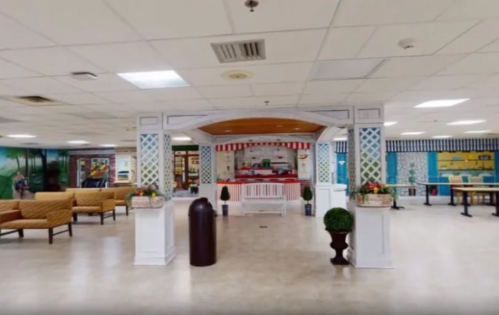 Interior view of a shopping mall food court area with decorative elements and seating.