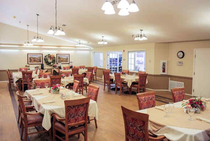 A well-lit dining area with neatly arranged tables and chairs, featuring elegant decor.