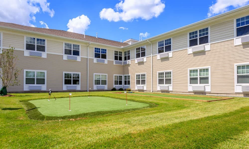 A residential building with a small putting green on a sunny day.