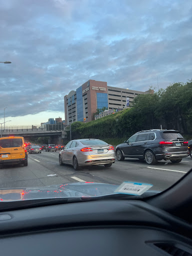 A view of a busy highway with cars in traffic under a cloudy sky.