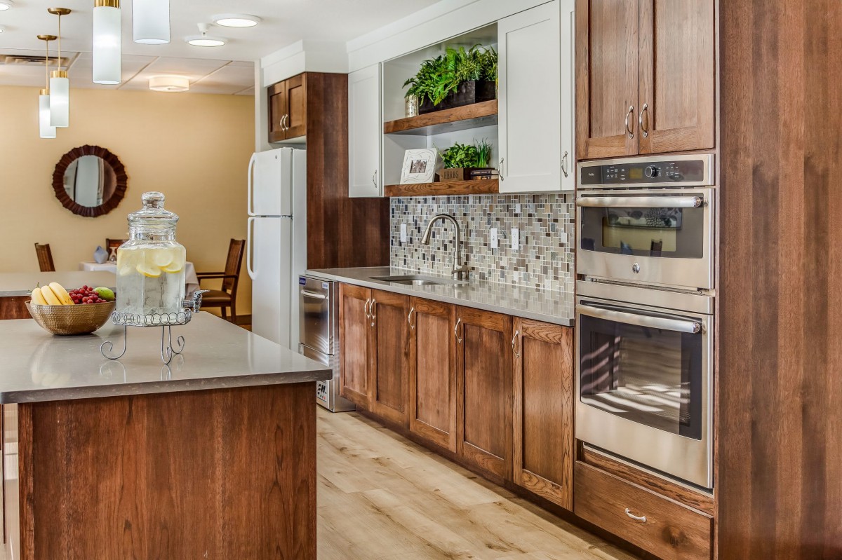A modern kitchen with wood cabinets, stainless steel appliances, and decorative backsplash.