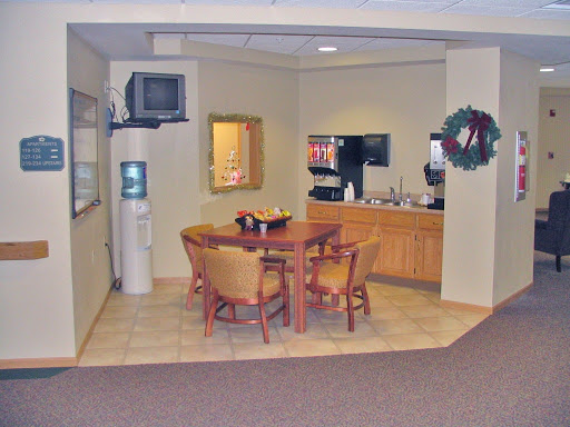 A cozy office break room featuring a dining table and kitchenette.