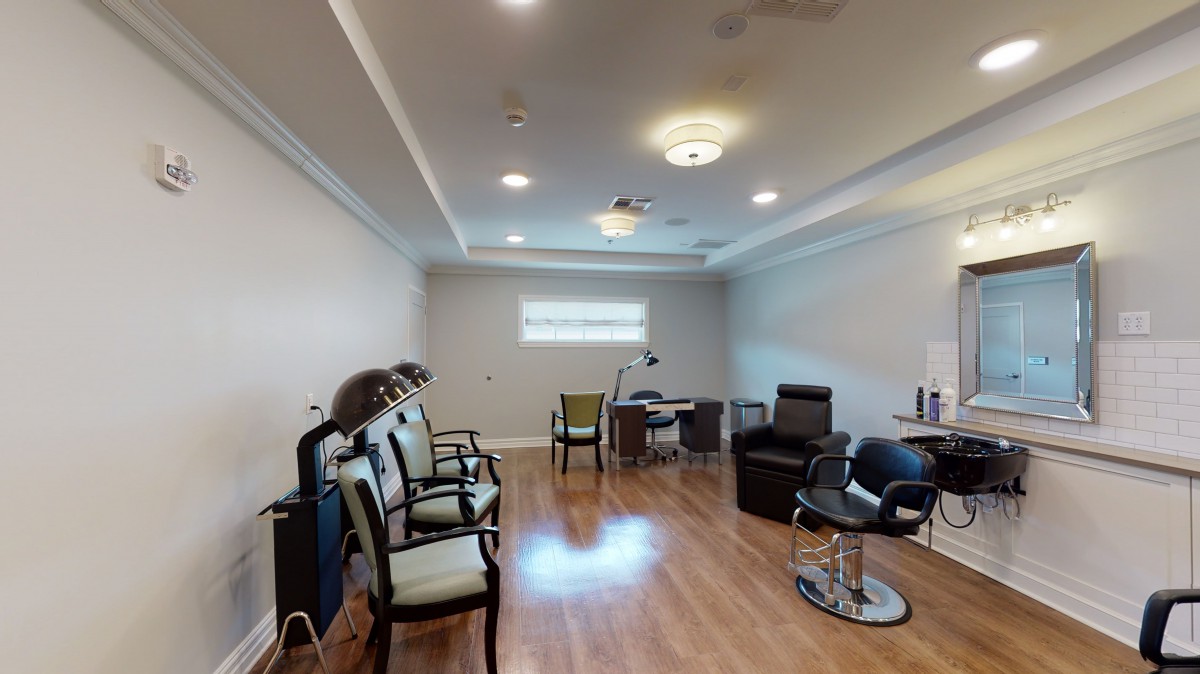A bright and spacious salon interior with seating and workstations.