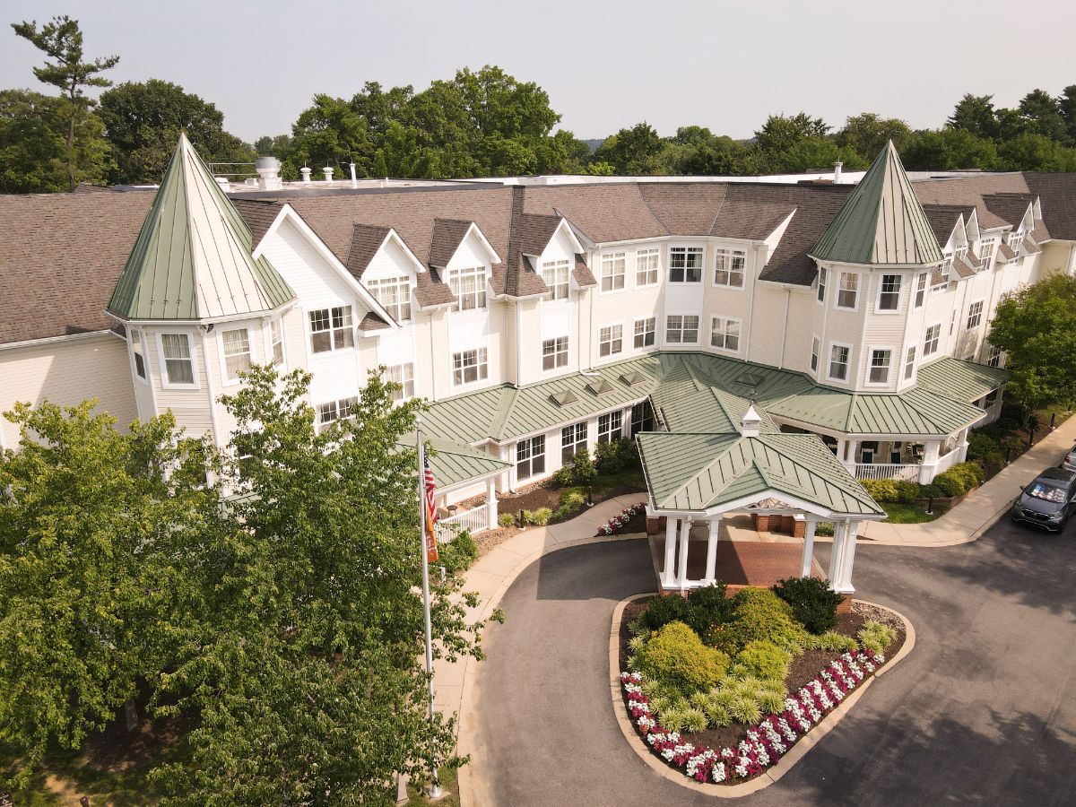 Aerial view of a residential building with green rooftops and landscaped entrance.
