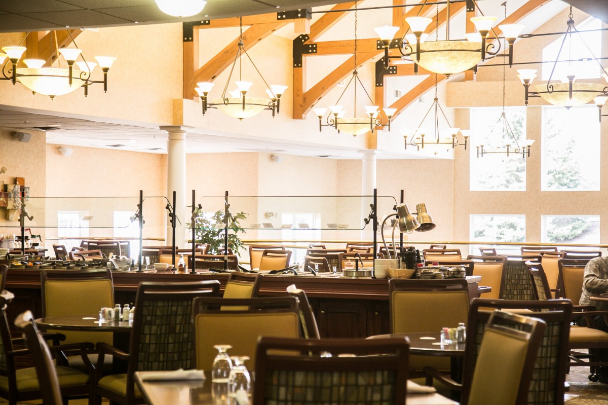 A spacious restaurant dining area with elegant lighting and neatly arranged tables.