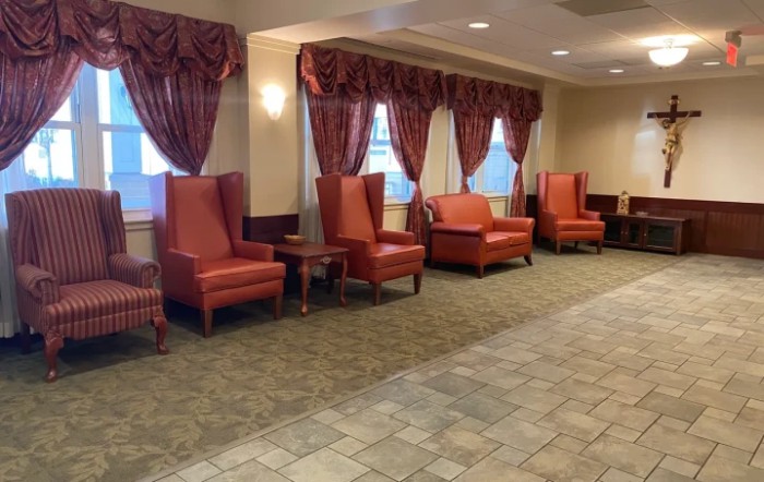 A lobby seating area featuring red upholstered chairs and matching curtains.