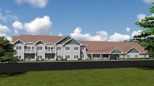 A modern residential building with a spacious lawn under a clear blue sky.