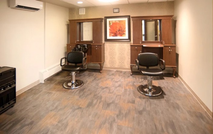A clean and modern salon interior with two hairstyling stations featuring chairs and mirrors.