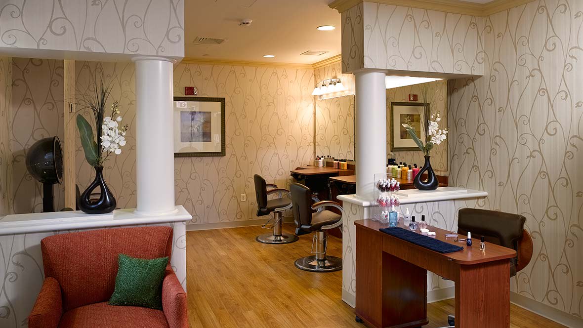 A well-furnished salon interior featuring styling chairs and a large mirror.