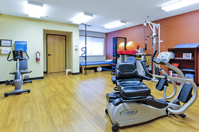 A spacious fitness room equipped with various exercise machines and equipment.