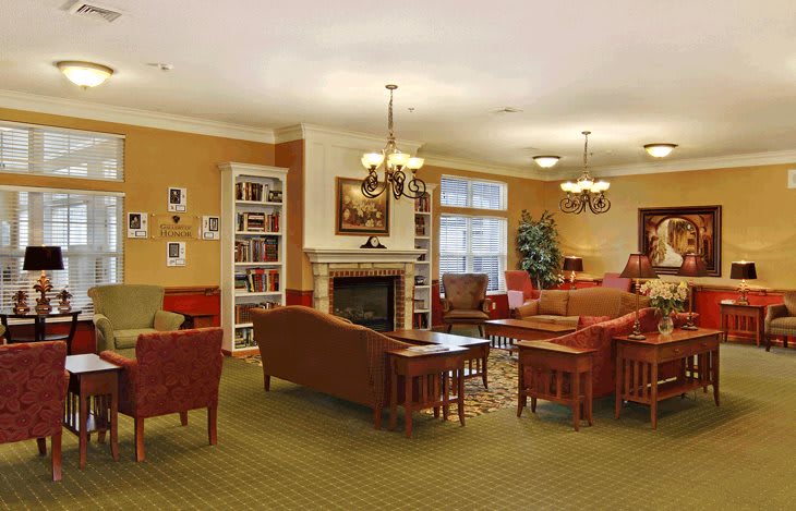 A cozy living room with comfortable seating, a fireplace, and bookshelves.