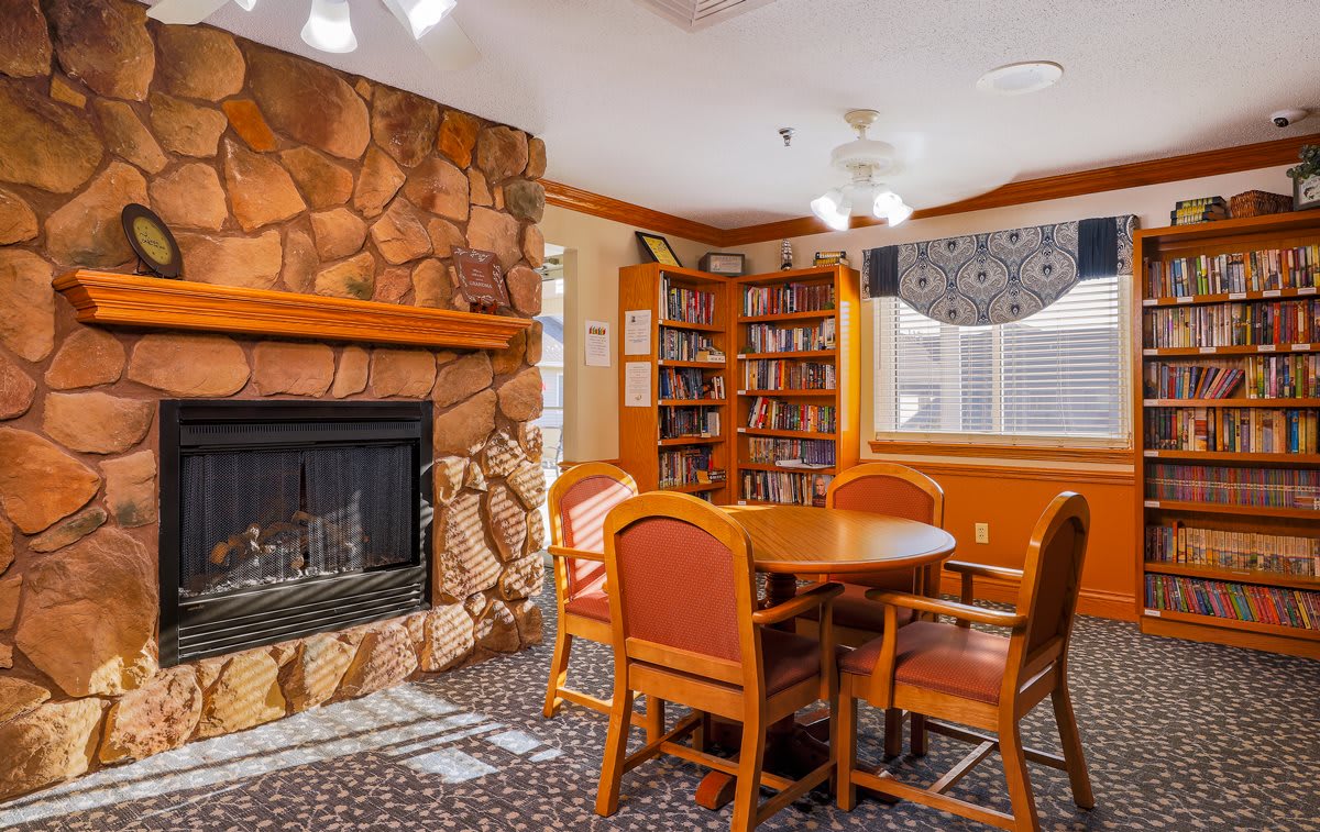 A cozy reading area with a stone fireplace and bookshelves.
