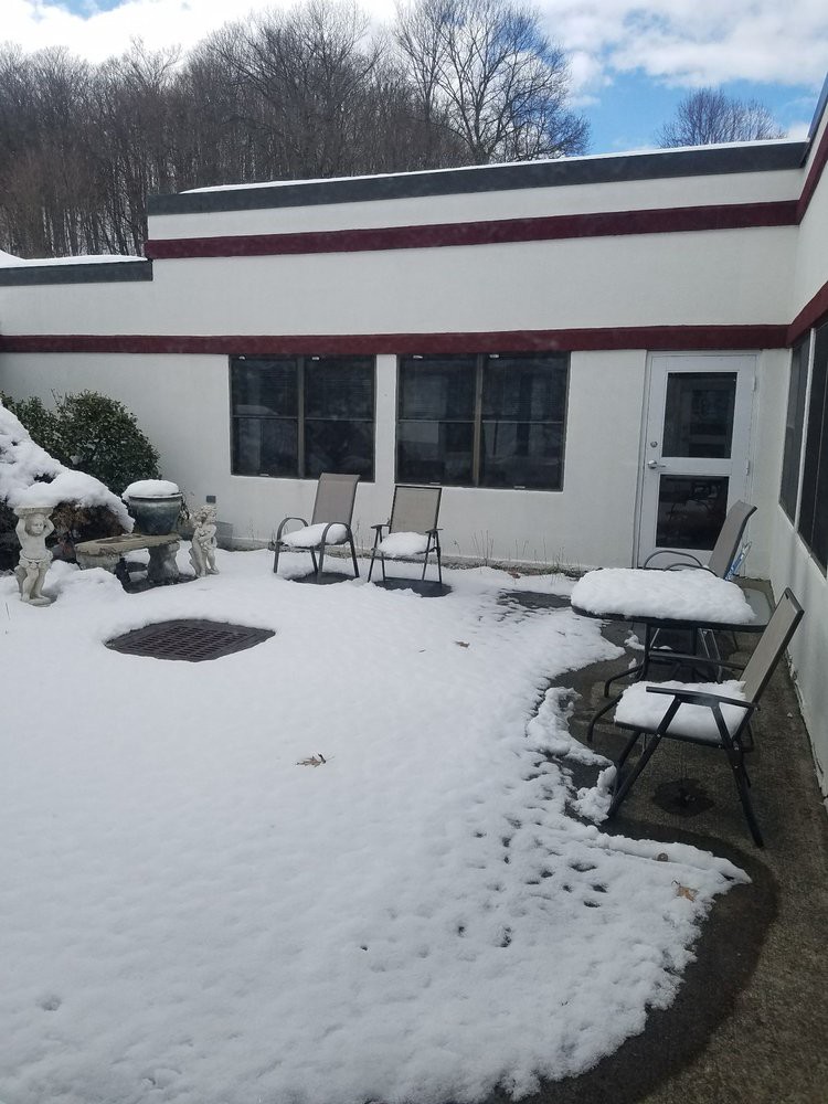 A snow-covered courtyard with patio furniture during winter.