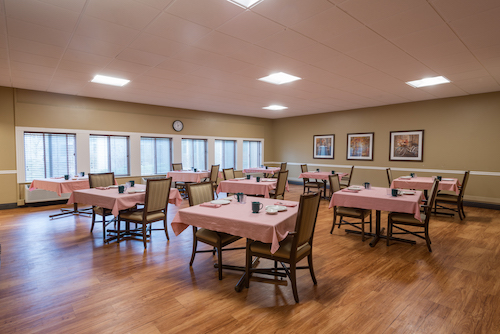 A spacious dining area with neatly set tables and a warm, welcoming atmosphere.