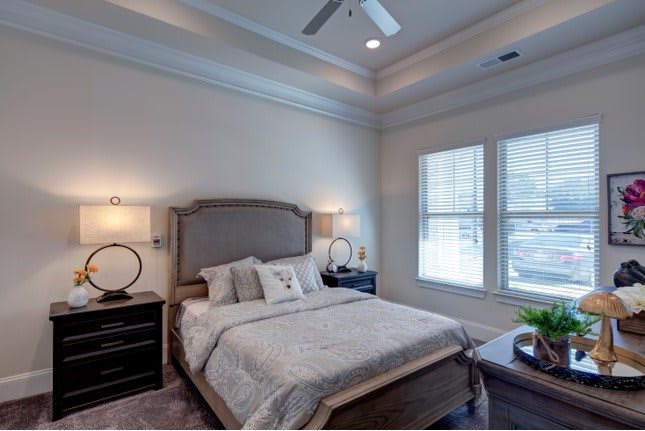 A cozy and elegantly designed bedroom with neutral tones, featuring a stylish bed and bedside lamps.
