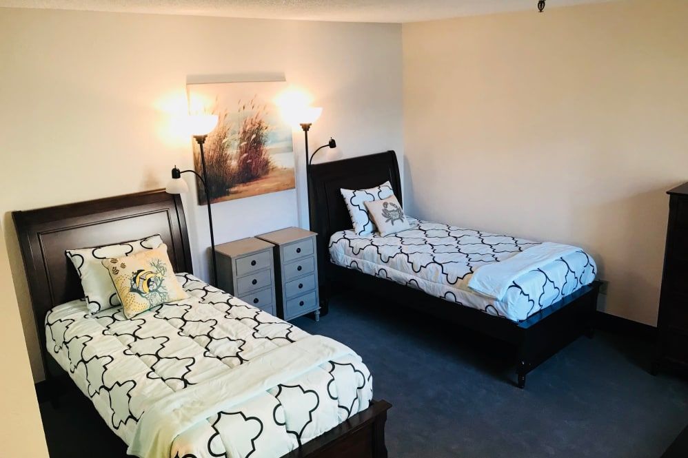 A cozy bedroom with twin beds and modern decor.