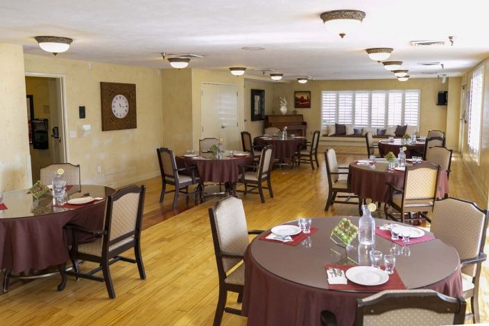 A cozy dining area with neatly arranged tables and chairs, set for a meal.