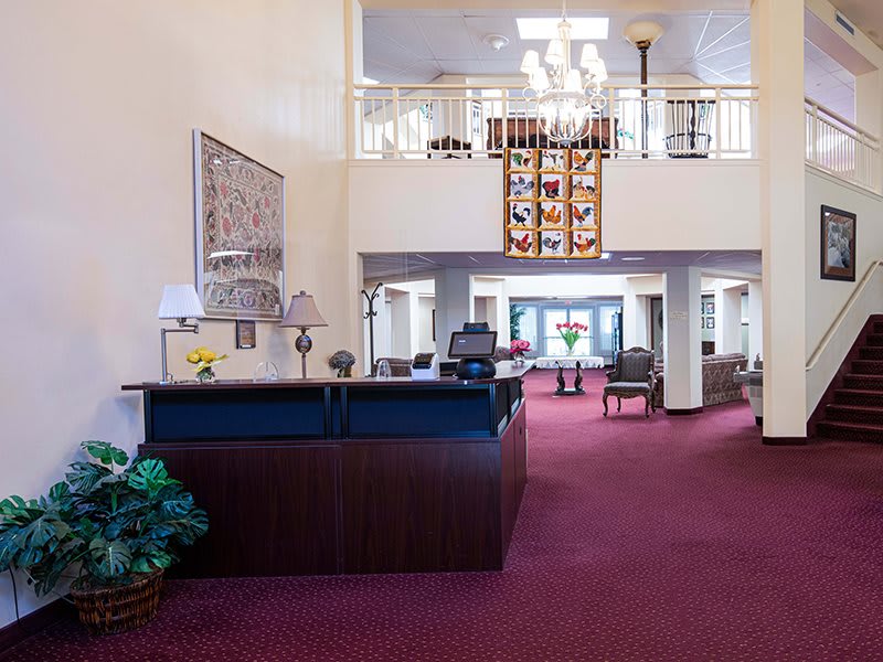 A spacious lobby with a reception desk, featuring elegant interior design and decor.