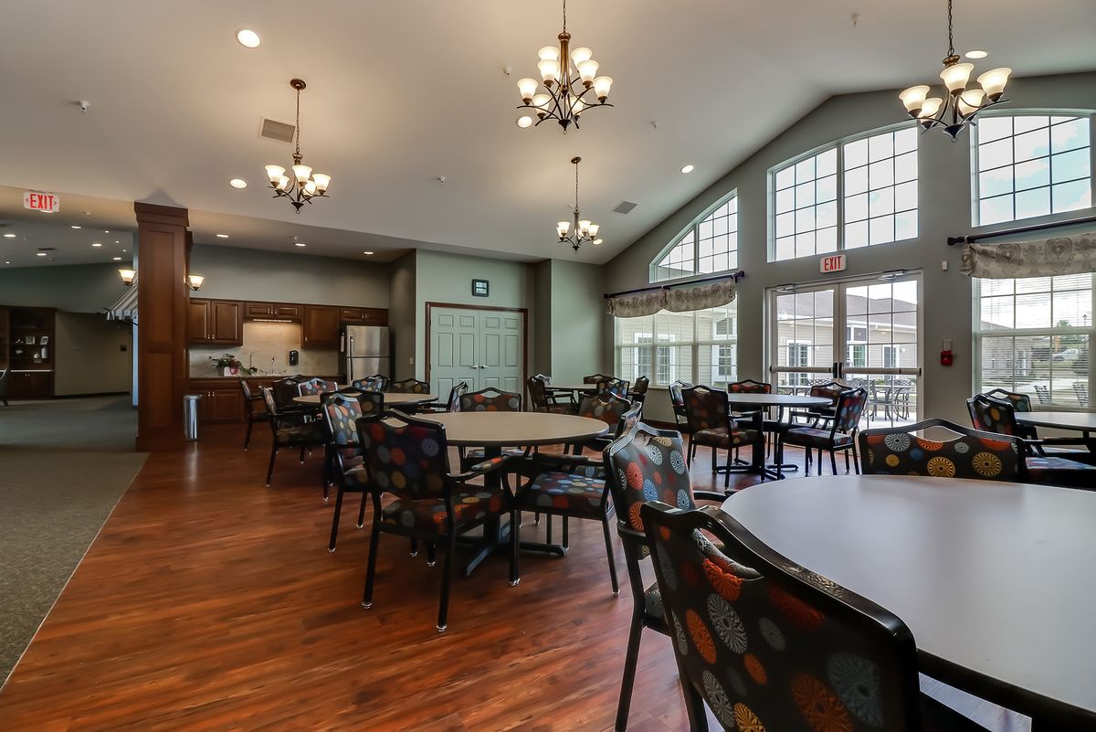 Spacious dining area with large windows and chandeliers.